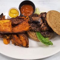Grass-fed beef burger with gluten-free bun and sweet potato wedges