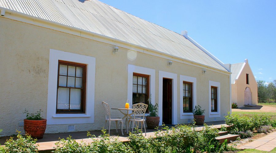 Ostrich Nest Cottage
This unit offers 3 seperate ensuite bedrooms each with their own private bathroom with separate bath & shower. Communial lounge with tv and fireplace. 
Ceiling fans, tea/coffee facilities, mini fridge, hairdryer, tv, bathrobes and amenities. Heaters and electric blankets supplied in the winter. Enjoy the views of the mountains and surrounding farmlands from the patio. Situated 1km from the main house and restaurant, but a few metres from the Hoepoe Cottage.
