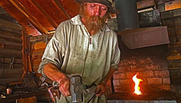 Blacksmith Ryan pounding iron during a Mountain Man Trade Fair.