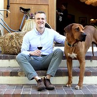 Winemaker Kristopher Tillery with winery dog Kuba at the entrance to the cellar.