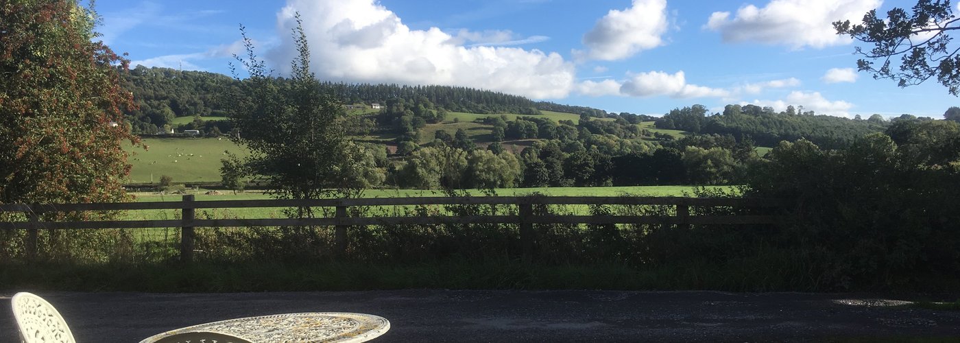 View from the front of the cottage with seating outside to take in the scenery