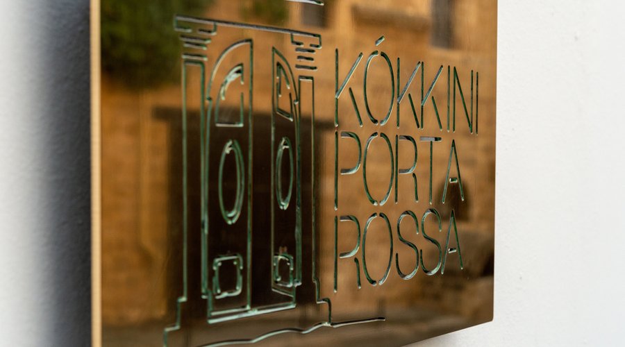Brass sign with our logo, reflecting the  beautiful house across our entrance.