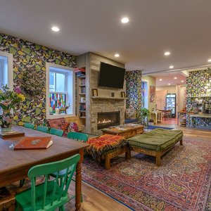 Our common area, furnished with funky decor that's perfect for mingling with fellow travelers. You can also see a peek of our kitchen (available to all our guests!), and our coffee station, where we serve up AMAZING local coffee every morning