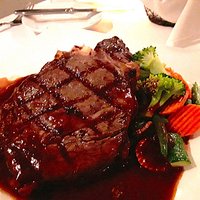 Black Angus Ribeye topped with rosemary red wine demi glace, roasted rosemary potatoes and seasonal vegetables