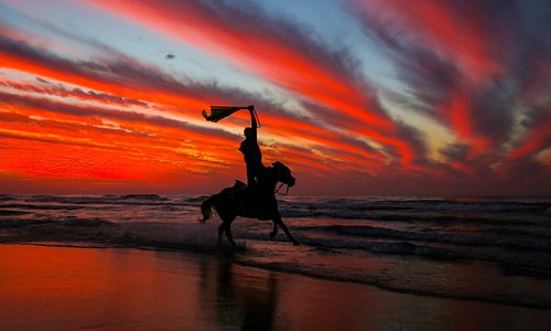 Palestinese a cavallo su una spiaggia a ovest di Gaza si gode il tramonto poco prima dell'inizio dei festeggiamenti per il nuovo anno  (Photo by MAHMUD HAMS / AFP)