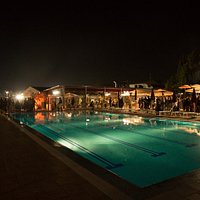 Piscina di notte con ristorante.