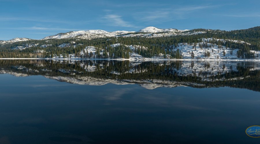 A winter's look at Payette Lake in McCall Idaho January 2019. A beautiful day with just enough hints of snow on the mountains. The deep blue water reflects the winter mountains. 