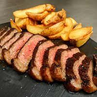 La tagliata di Picanha irlandese (400 grammi) con patate rustiche, servita su pietra calda.