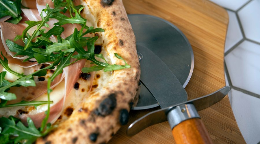 Prosciutto pizza with fresh mozzarella, arugula and parmesan cream.