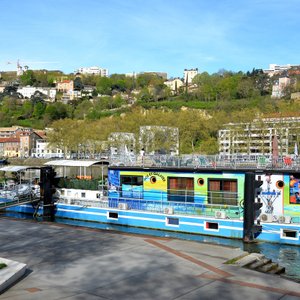 INSOLITE, AGREABLE, CALME, EN PLEIN COEUR DE LYON Une péniche avec studios meublés et chambre d’hôte : une manière originale de découvrir Lyon ! Envie d’une expérience originale et insolite ? Nous vous accueillons toute l’année pour vos séjours loisirs comme pour vos missions professionnelles. Découvrez nos offres. Notre péniche est amarrée en bord de Saône, au cœur de Lyon. Située entre les quartiers de Bellecour et Confluence, à deux pas du Vieux-Lyon.