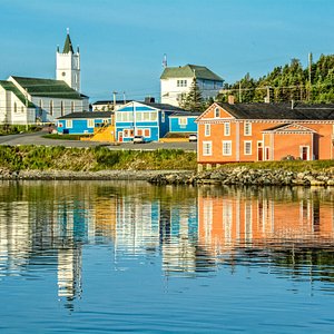 The Anchor Inn Hotel and Hodge Premises from the Twillingate harbour with the St. Peter's Anglican Church and the Wooden Boat Museum in the background.