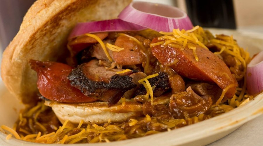 Woodie Dog a whole smoked hot link on a piece of Texas Toast topped with spicy baked beans and shredded cheddar cheese.