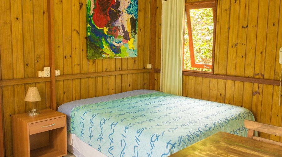 Bangalô Standard: Quarto para casal, com ventilador de teto (sem ar-condicionado), OI TV com 118 canais, banheiro, cofre e varanda.