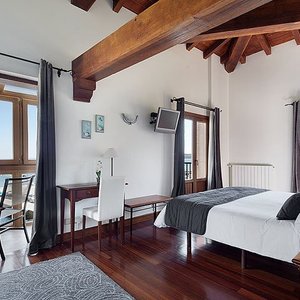 Habitación DOBLE SUPERIOR con vistas tanto al puerto como a la playa. Dispone de un mirador y dos balcones. Cama king size con posibilidad de poner otras dos camas supletorias.