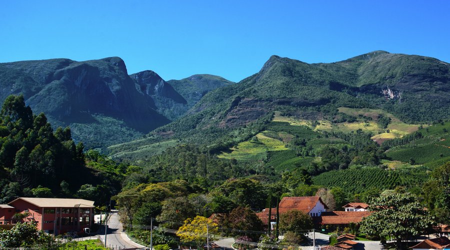 Aos fundos o Parque Nacional do Caparaó, e famosa formação rochosa: Face de Cristo.