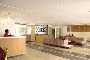 Cosmopolitan Hotel in Madurai, image may contain: Indoors, Foyer, Person, Table