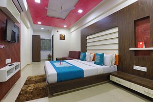 OYO 9238 Hotel Meet Palace in Ahmedabad, image may contain: Bed, Interior Design, Rug, Monitor
