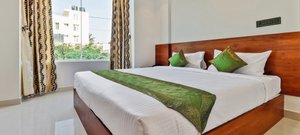 Treebo Trend Blu Orchid in Bengaluru, image may contain: Cushion, Home Decor, Interior Design, Bed