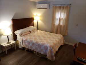 Pinecone Motel in Sussex, image may contain: Furniture, Bedroom, Bed, Remote Control