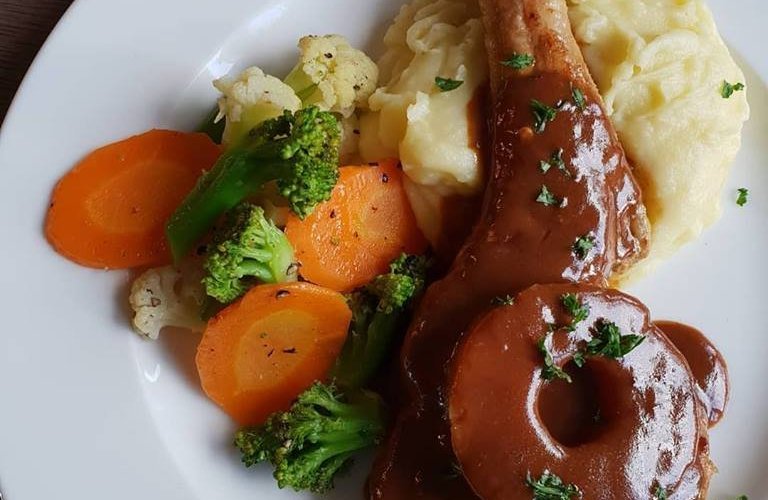 Tender grilled Pork chop with BBQ sauce topped with grilled pineapple and served with choice of fries or mashed potatoes and a side of salad or steamed vegetables.