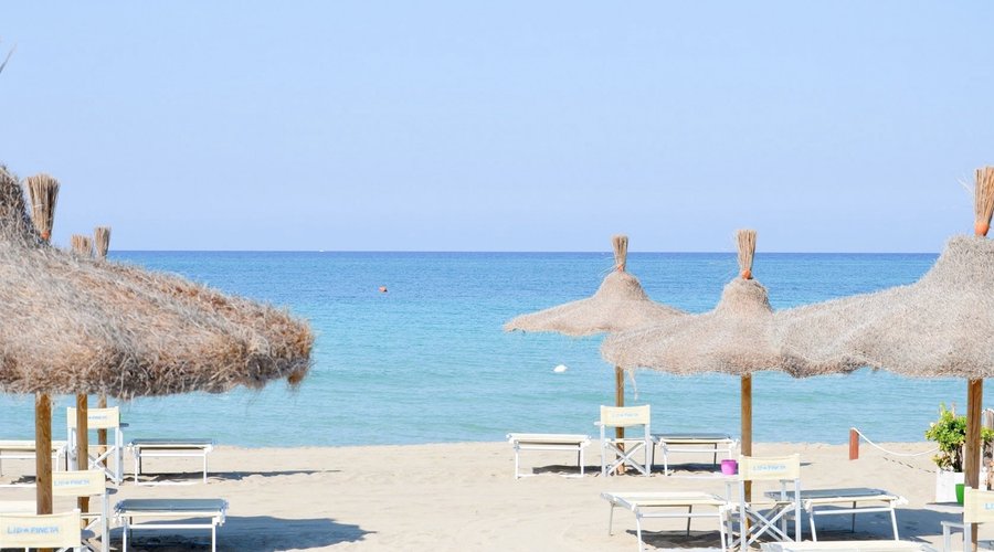 Spiaggia del Monteforte Resort a Marina di Ugento, in zona esclusiva e riservata con ombrelloni in palma di cocco e letti king-size.
