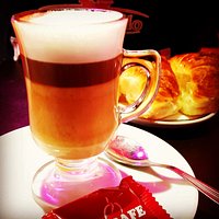 Café cortado en jarrito de vidrio con medialunas