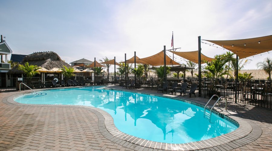 Heated pool with surrounding table seating for The Palm Grill restaurant.