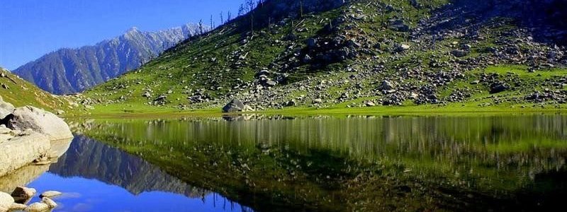 Clear weather; A place with Picturesque view. peaceful valley of snow with white water lake;