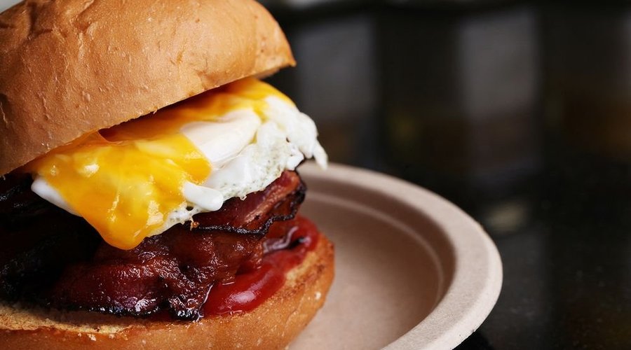 Hangover. Bacon, grilled chicken, sunny side up egg, avocado on burger bun and french fries