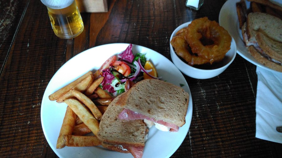 Chicken and bacon on brown with bowl of onion rings