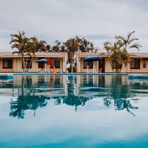 Foto tomada en alrededor de la piscina, la vista de dicha foto son los bungalows y los árboles que existen dentro del local
