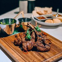 Harissa spiced lamb cutlets - Australian lamb cutlets rubbed with Harissa spices and barbequed,served with orange and pistachio couscous, buttered snow peas, chermoula dressing.