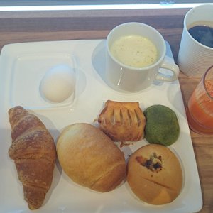 朝食の焼き立てパン、味付けゆで卵、スープとジュースとコーヒー。食事中に焼き立てクロワッサンを席まで配りに来ていた。