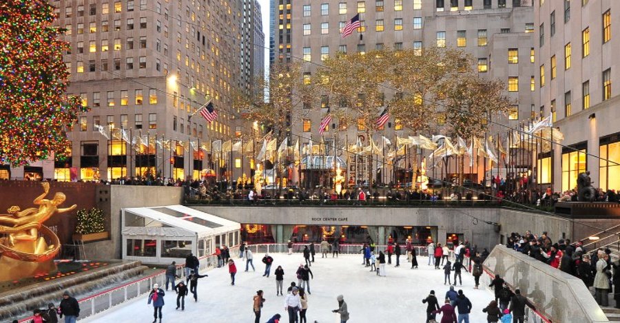 Authentic street scene of The Rink at Rockefeller Center capturing skaters enjoying the ice, with buildings in the background