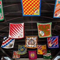 The Contrada (Neighborhood) flags of Siena, Italy fly above the entrance to Il Palio