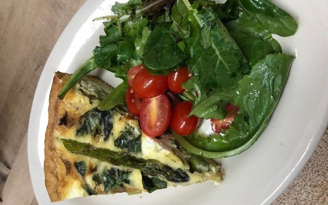 Asparagus & Spinach Quiche with flaky house-made crust. Served here with a side of greens.