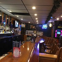 The bar at Ginger's Hide-Away, with some tables in the bar area; separate dining area on other side of the wall to the left.