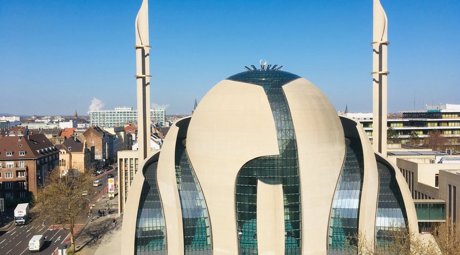 Ein architektonisches Highlight von außen und innen.
Der Wettbewerbsentwurf stammt von den Architekten Gottfried und Paul Böhm, die Innenraumgestaltung des Gebetssaals von Semih Irteş. Eine Synthese zwischen tradierten Gestaltungsmustern und zeitgenössischem Entwurf - spirituell, inspirierend und einladend!