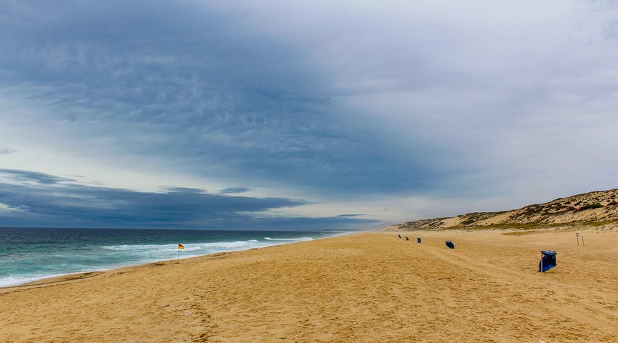 Esta praia bela alentejana, rodeada de dunas e de um extenso areal e de um pinhal, fica situada entre a Reserva Natural das Lagoas de Santo André e da Sancha, freguesia de Vila Nova de Santo André.