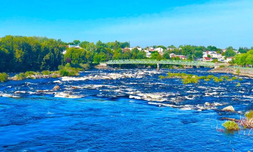 Rio Saguenay visto das margens da cidade de Alma. Ao fundo a passerelle Damase-Boulanger.