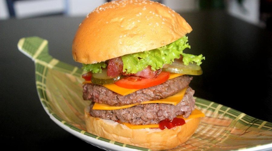 Double Dem burger also called BG4. Double Australian beef patties, cheddar, gherkins, bacon, tomatoes and salad. Savory French bun.