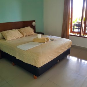 The room is spacious with a comfortable double bed.