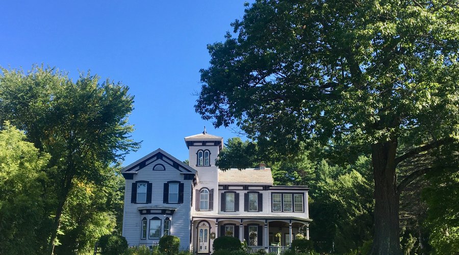 A beautiful old home with lovely grounds surrounding it.