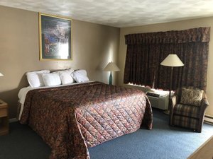 Village Inn Motel & Apartments in Holt, image may contain: Bed, Furniture, Lamp, Painting