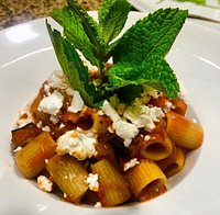 Os presentamos nuestro plato de mezze maniche con salsa de tomate casero, berenjena frita y queso de cabra con un copo de menta fresca por un olor fresco y agradable.