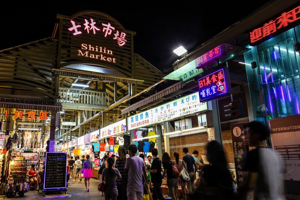歡迎你們到士林夜市參觀。 那裡有許多不同的小吃和遊戲能讓你好上整的下午，不過來士林夜市前也是需要做功課的。早期商人在士林完成農產品買賣交易後，在附近的三腳渡裝貨，沿基隆河經過番仔溝轉往淡水河，將貨物運送到大稻埕、艋舺等地。 1909年，設立「士林市場」一直發展至今。 過去的交易主要集中於媽祖廟「慈諴宮」之廟前廣場，然而市場攤販逐漸侵占廟宇用地，於是慈諴宮築起圍牆保留僅存的狹窄廟地，圍牆只能任由攤販使用。（以上資料來源：士林夜市- 维基百科，自由的百科全书 - 維基百科）