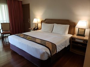 Waterfront Insular Hotel Davao in Mindanao, image may contain: Chair, Lamp, Bed, Table Lamp