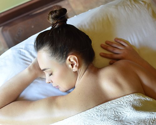 Spouses Receiving Relaxing Beauty Treatment Lying At Luxury Spa