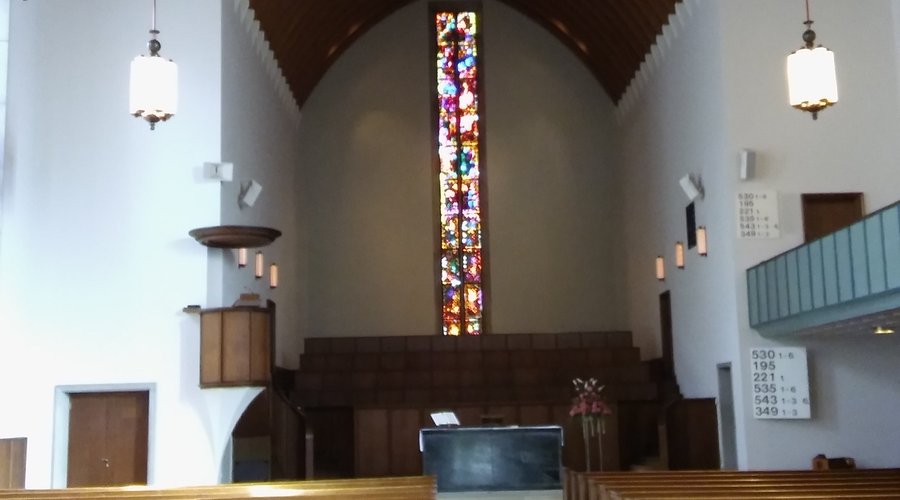 Interior view with arched wooden ceiling and Giacometi stained glass