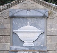 Sur la façade de cette tombe, on peut y voir la « soupière » qui est en réalité la représentation d’une urne funéraire !
